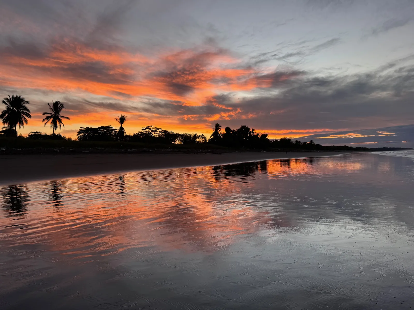 Fiery sunrise reflected across Playa Hermosa beach in Costa Rica
